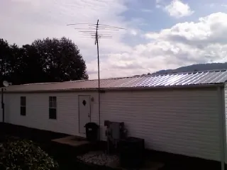 New metal roof on a single wide mobile home with a TV antenna in Jbsa Lackland
