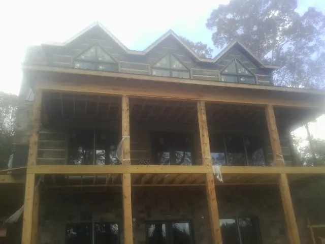 Dormers and porch framing on a large log home under construction — Roof Coating work by our crew in Jbsa Lackland
