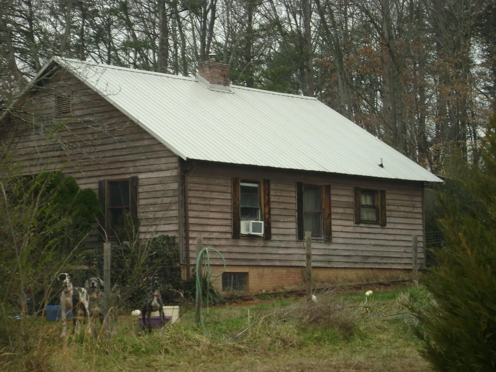 White metal roof on an old wood sided farmhouse, from a Metal Roof Installation job in Jbsa Lackland